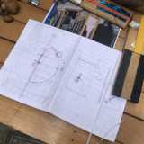 Tra aeroplanini di carta, rocchetti in panno per avvolgere i fili e curiosi �antistress� fatti con pezzi di legno che sbattono tra di loro, l�uomo ci mostra il disegno di un suo progetto: una ruota a moto continuo